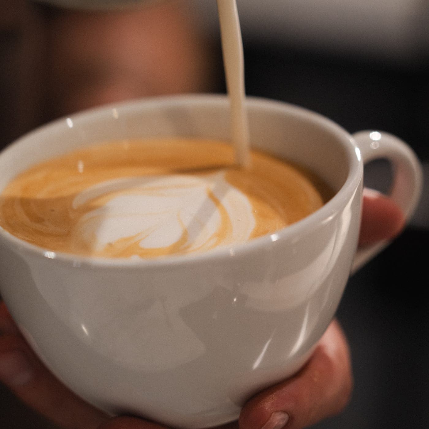 Milk being poured into a cappuccino