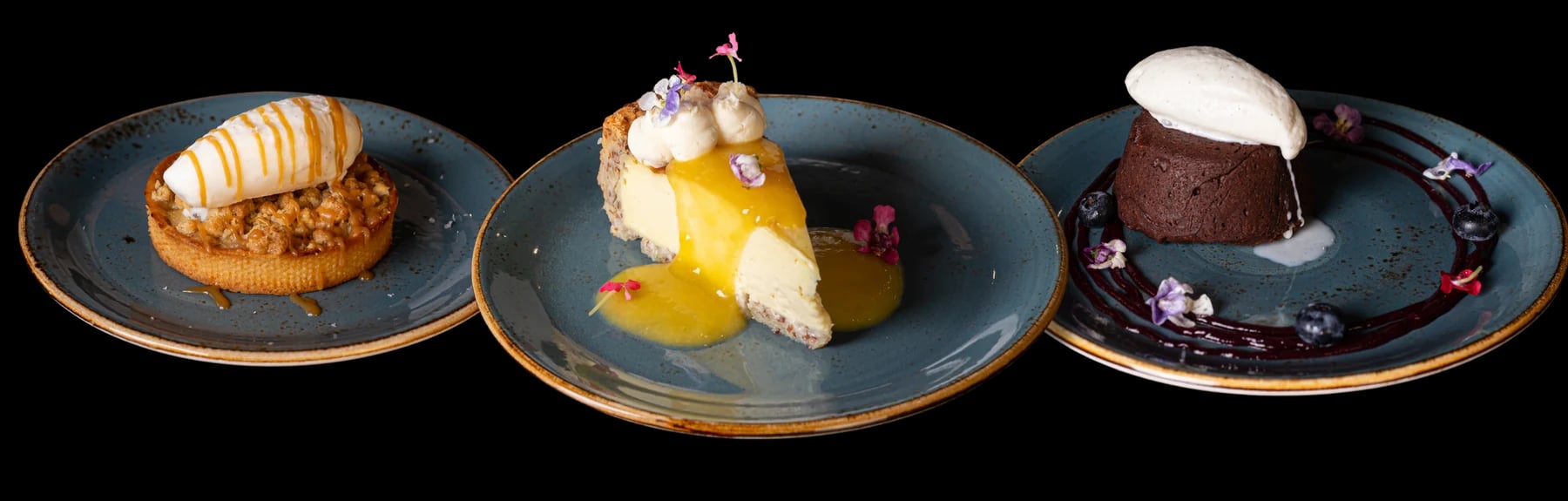 Three desserts: a tart with a scoop and caramel, a cheesecake slice with mango sauce, and a chocolate cake with cream and blueberries