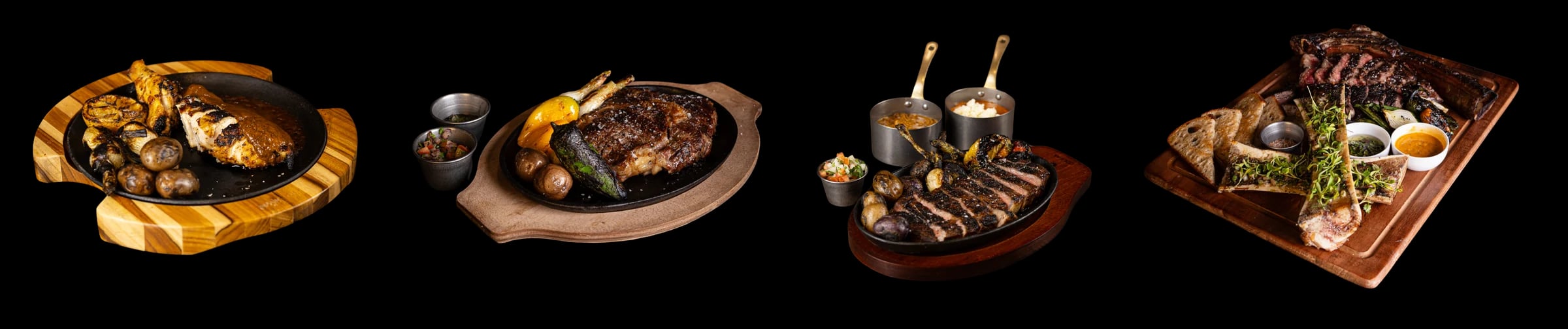 Cuatro platos: pollo con papas y cebollitas asadas sobre una tabla de madera, un corte en un plato de hierro con vasitos de salsa, un corte rebanado con papas y dos ollitas de cobre, y un corte con hueso sobre una tabla con huesos con tuétano