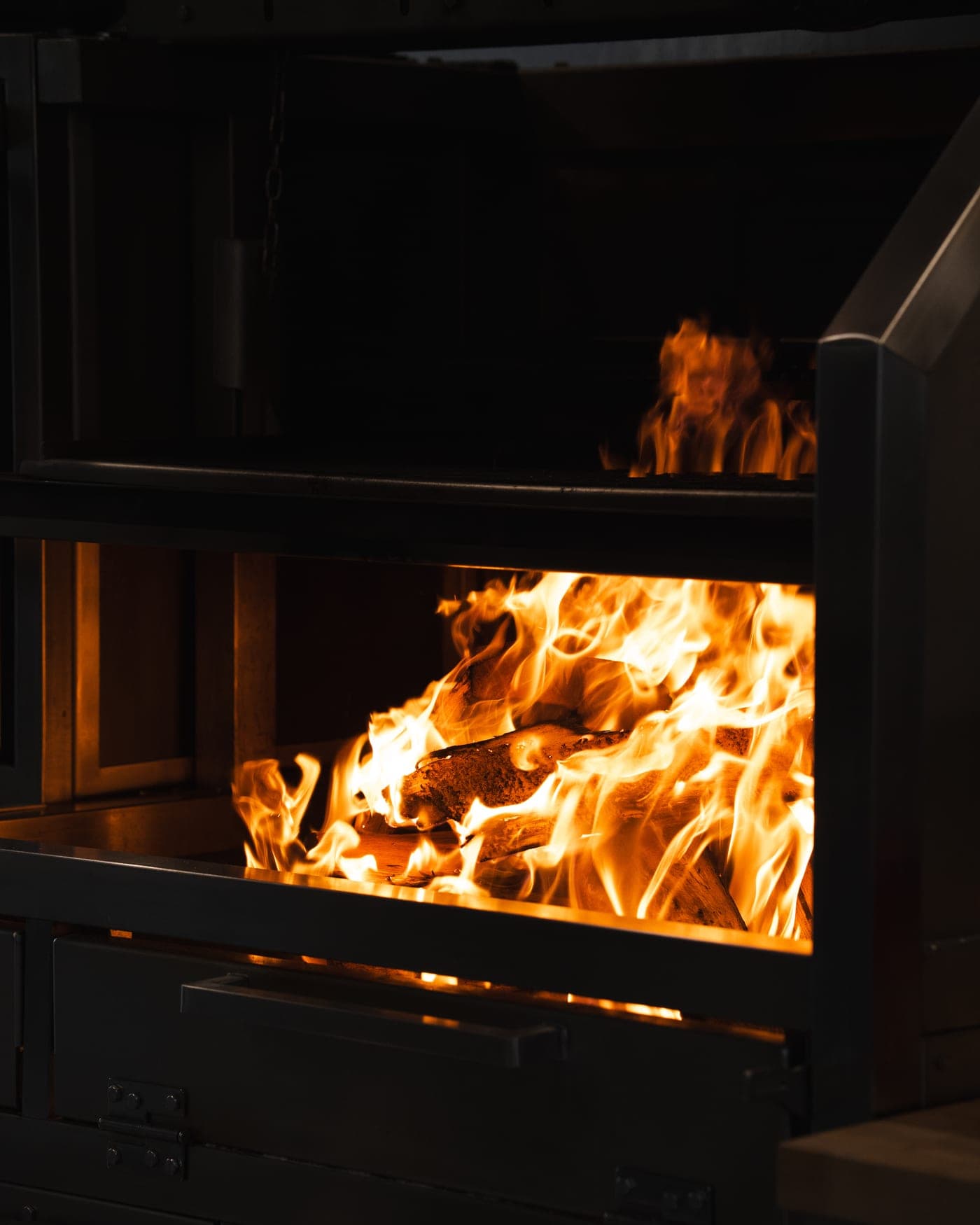 Leña ardiendo en el fogón de la parrilla