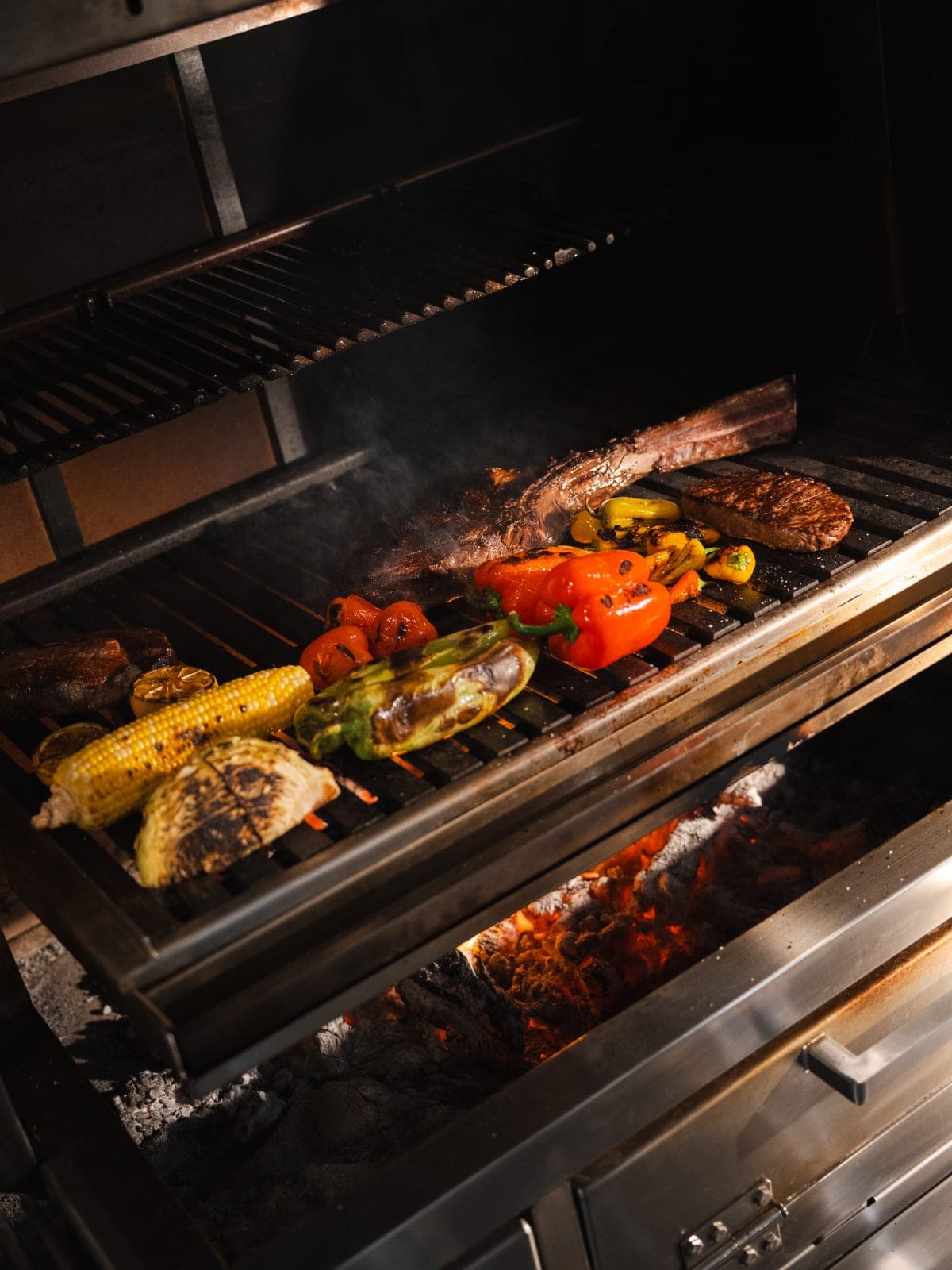 Steak, corn and peppers on the wood-fire grill
