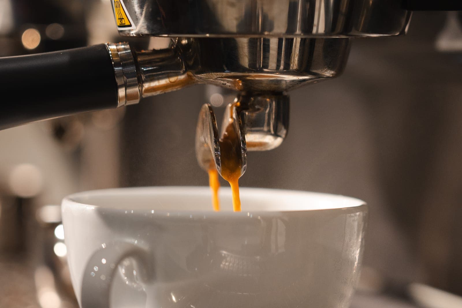 Espresso pouring into a white cup