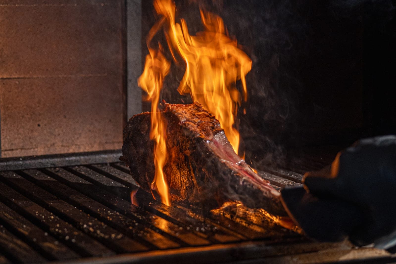 A tomahawk steak in flames on the grill