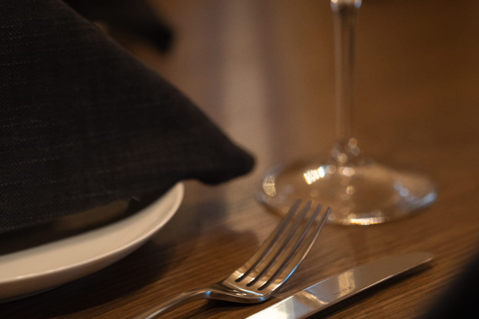 A fork and a wine glass on a set table